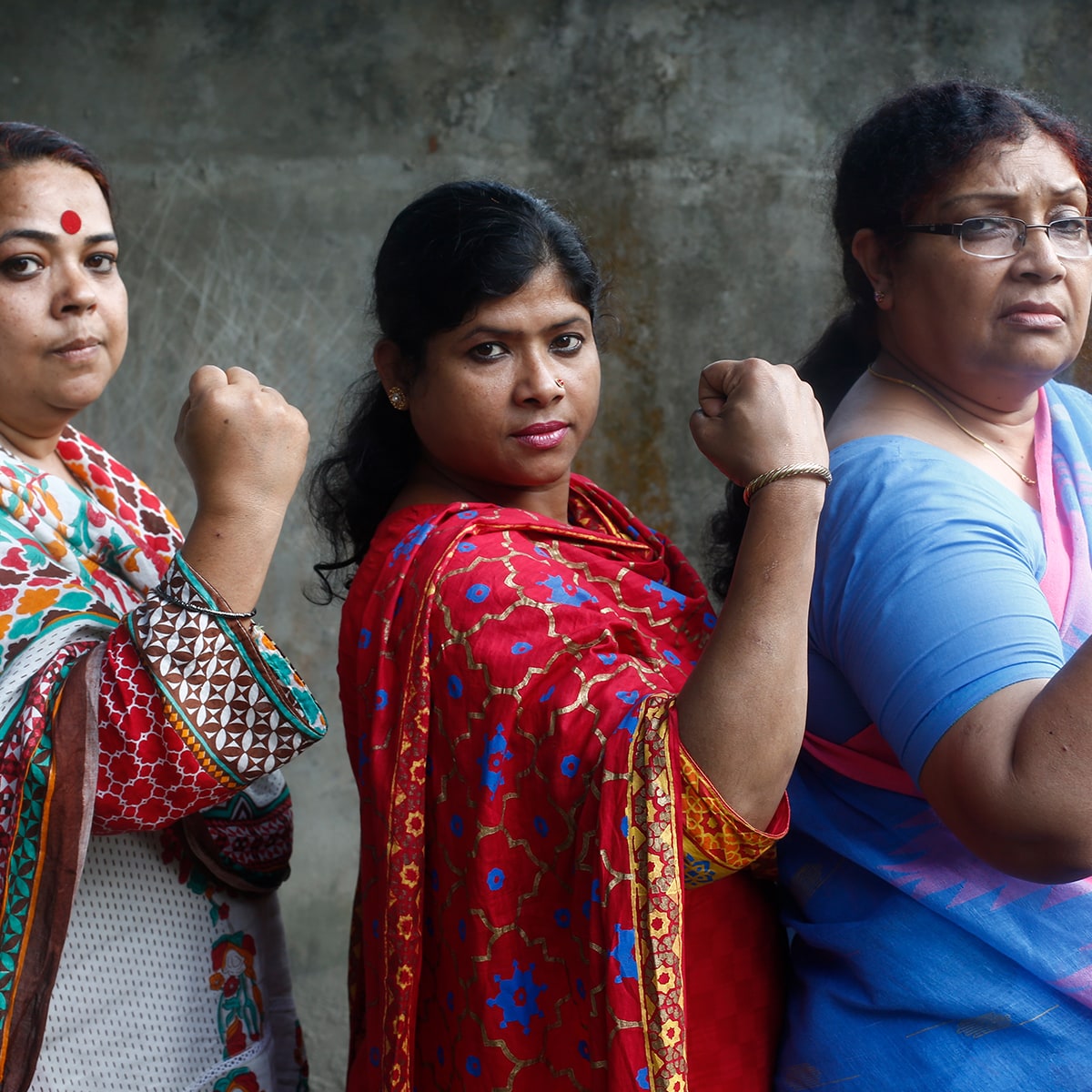 Three women holding up their fists