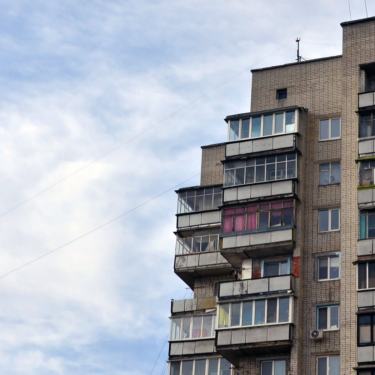 A run down apartment building against a blue sky