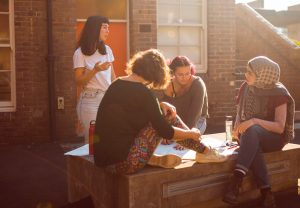 A group of four young women, sitting in a circle and having an planning conversation